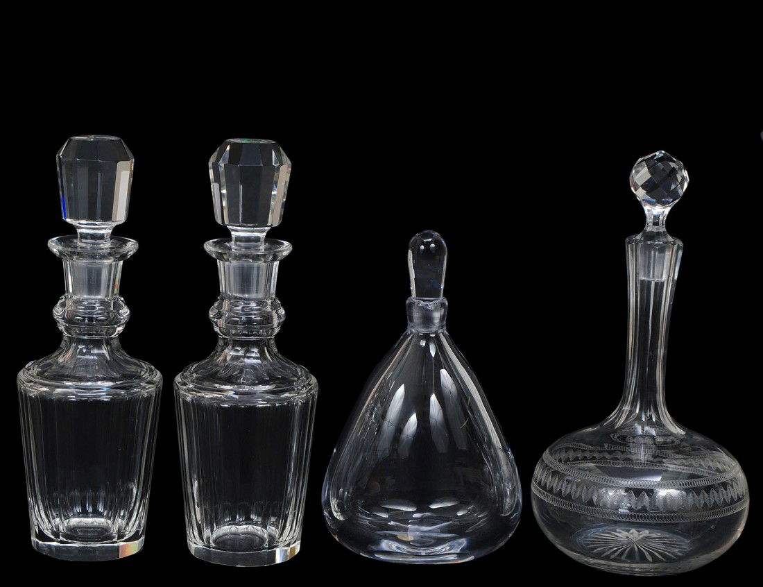 GROUP OF FOUR CRYSTAL DECANTERS: One by Orrefors, one engraved and a pair with fluted body. Heights 8 1/2" to 10 1/2". (Cond: chips) (125/175)
