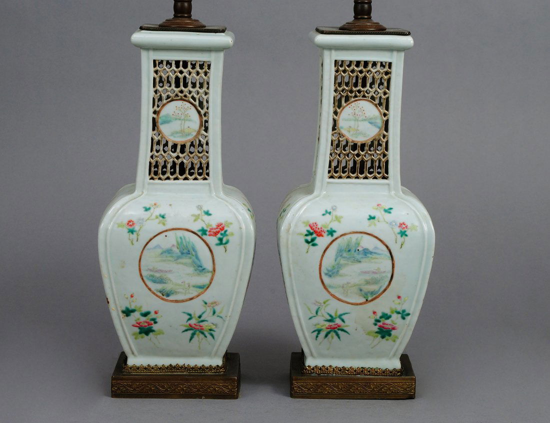 VERY FINE PAIR OF FAMILLE ROSE PORCELAIN VASES: Chinese. Qing Dynasty. Of square bottle form with tall reticulated neck, painted with landscape panels and blossoms. Height 11 1/2". (Now electrified) (Cond: minute chips to glaze) (1500/2000)