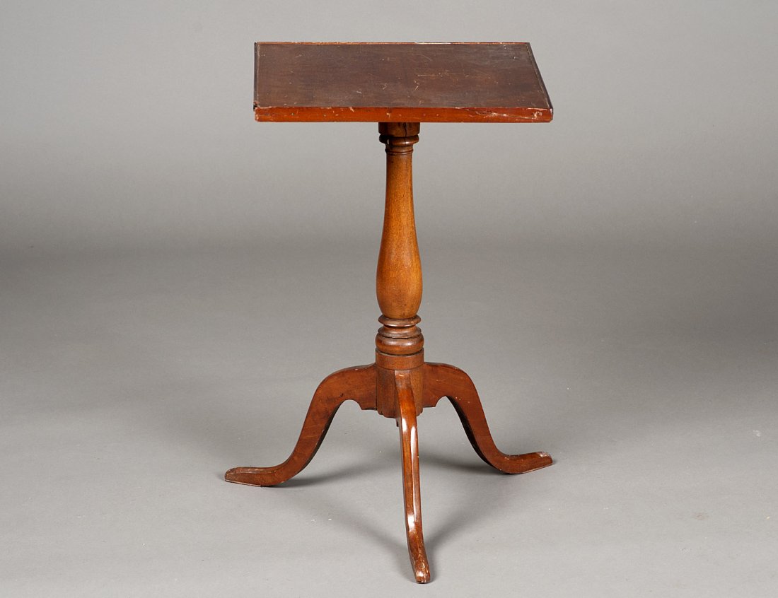 QUEEN ANNE STYLE CHERRYWOOD CANDLE STAND: American. Early 19th Century. With square top above a vase form standard, raised on a tripod ending in pad feet. Height 25 1/2". Diameter 16". (Cond: molding around top with losses) (200/300)