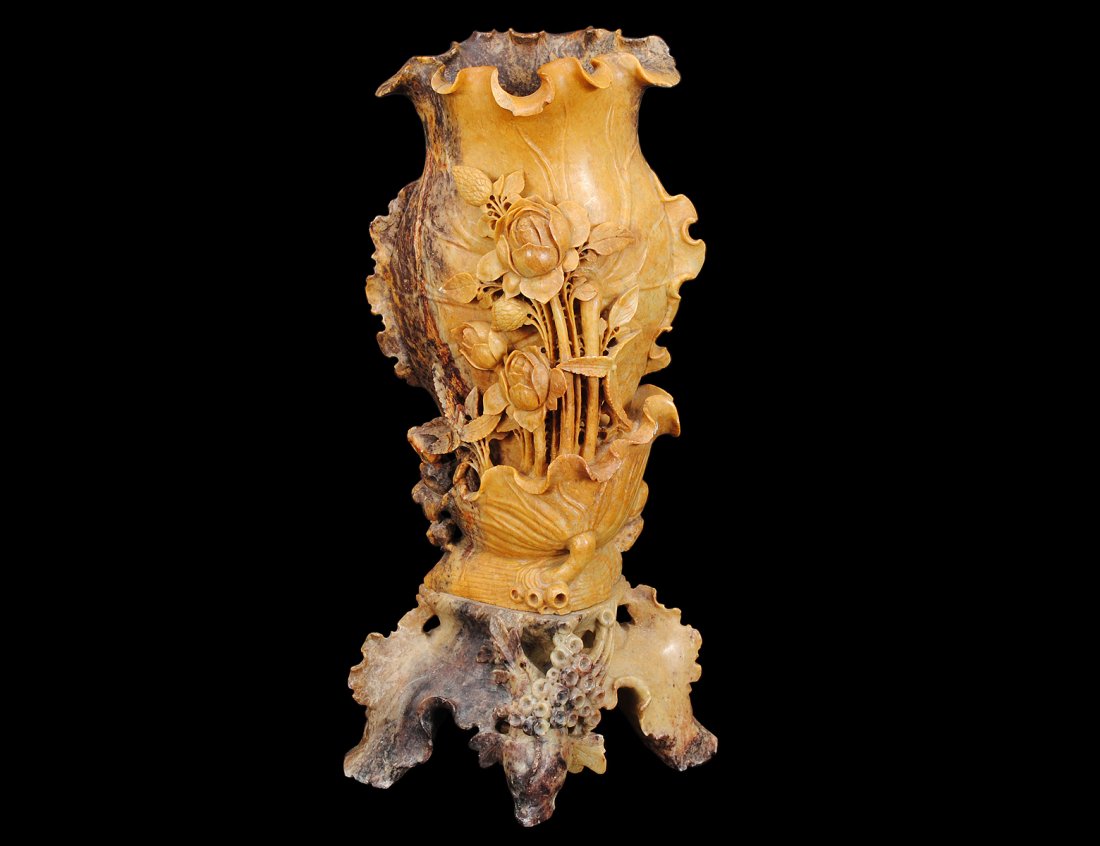 CARVED SOAPSTONE VASE: Chinese. Emerging from a lotus, raised on a rockery base. Height 15 7/8". (300/400)