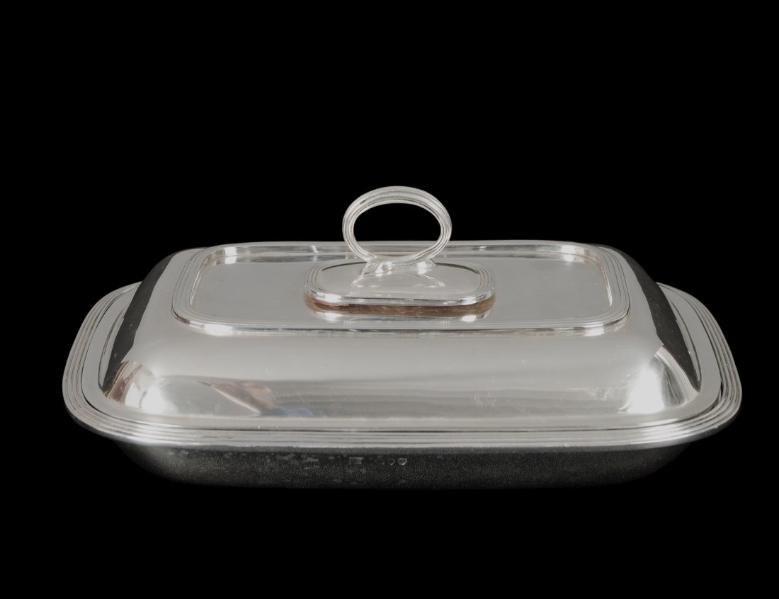 VICTORIAN STERLING SILVER ENTREE DISH AND COVER: English. London. 1891. Maker: E.H. Of rectangular shape with reeded edge, removable handle, associated with an English London 1913 sterling silver liner. Length 9 3/8". (41 oz) (800/1200)