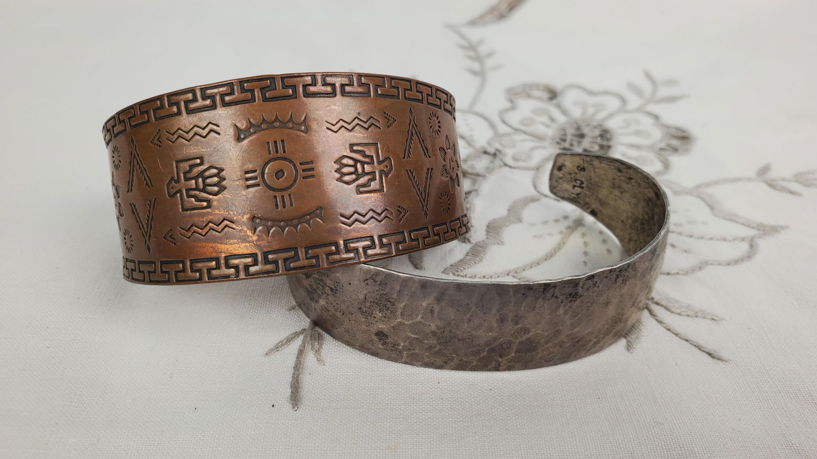 Two Vintage Native American Cuff Bracelets, one copper with stamped design, 2 1/2" w. (1 3/4": Two Vintage Native American Cuff Bracelets, one copper with stamped design, 2 1/2" w. (1 3/4" opening) and the other hammered and marked Sterling with maker's mark, 2 1/2" w. (1 1/4" opening)