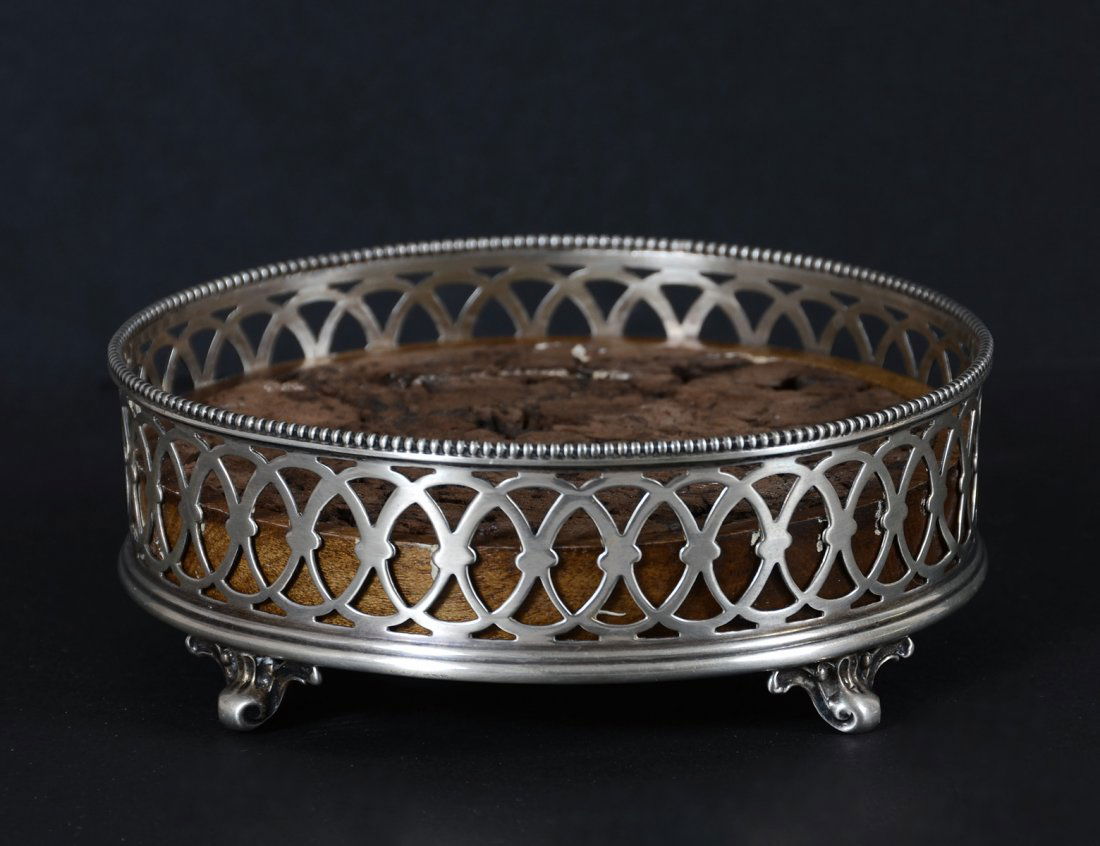 STERLING SILVER WINE COASTER: American. Late 19th Century. Maker: Gorham. Of circular shape with pierced sides and wood base. Diameter 4". (50/80)