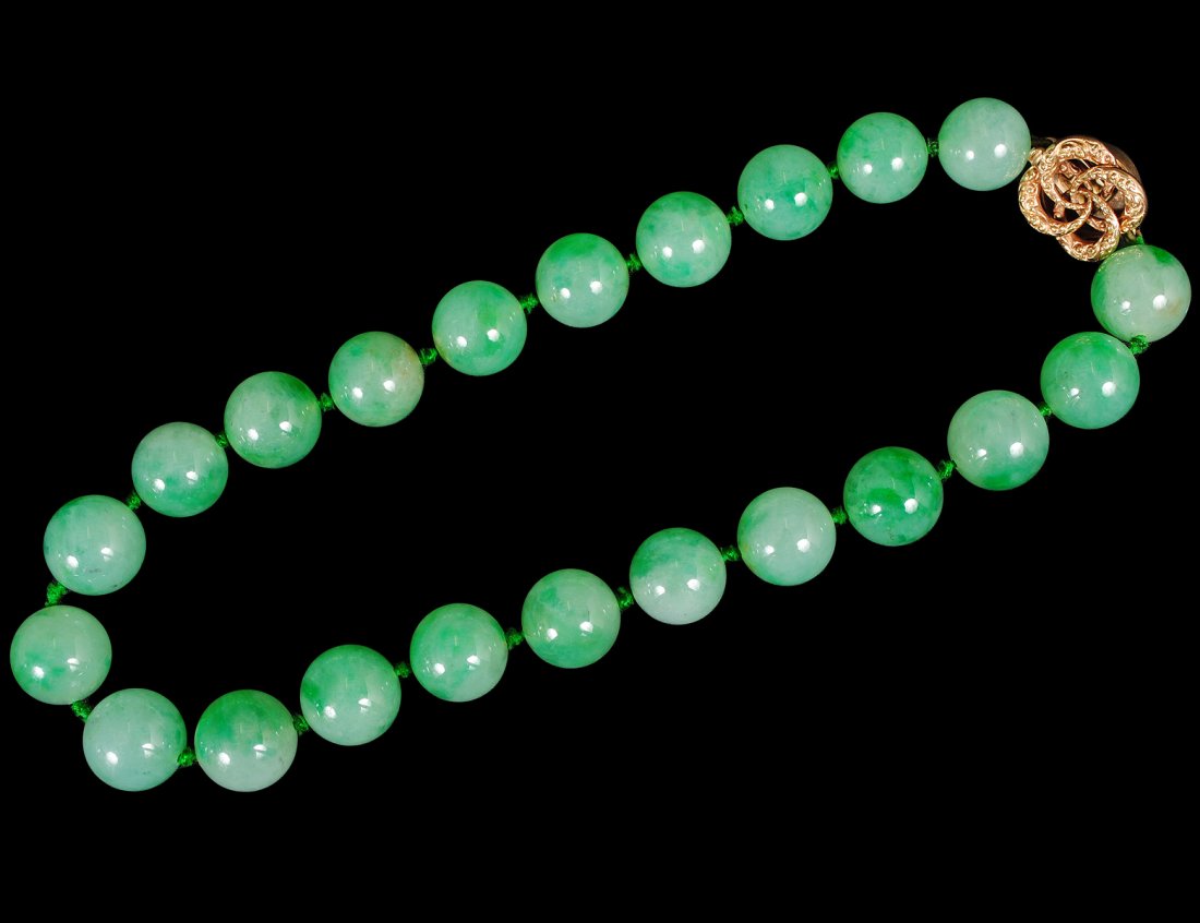 VERY FINE APPLE GREEN JADE AND FOURTEEN KARAT GOLD: Chinese. Composed of 16 mm uniform beads joined by a gold floral clasp. Length 16". (600/800) Note: This lot is being re-offered for sale due to the fact that Kat Yung Lok of 140-30 Ash Ave, Flushing,