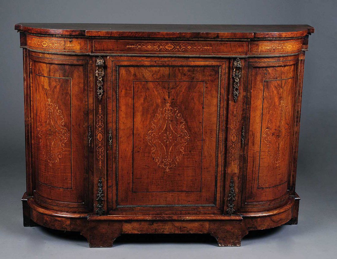 FINE VICTORIAN INLAID BURL AND WALNUT CREDENZA: English. 19th Century. The stepped D-shaped top above the inlaid frieze with gilt bronze borders encased with three cupboard doors, each with gilt bronze borders enclosing inlays, raised on a molded p