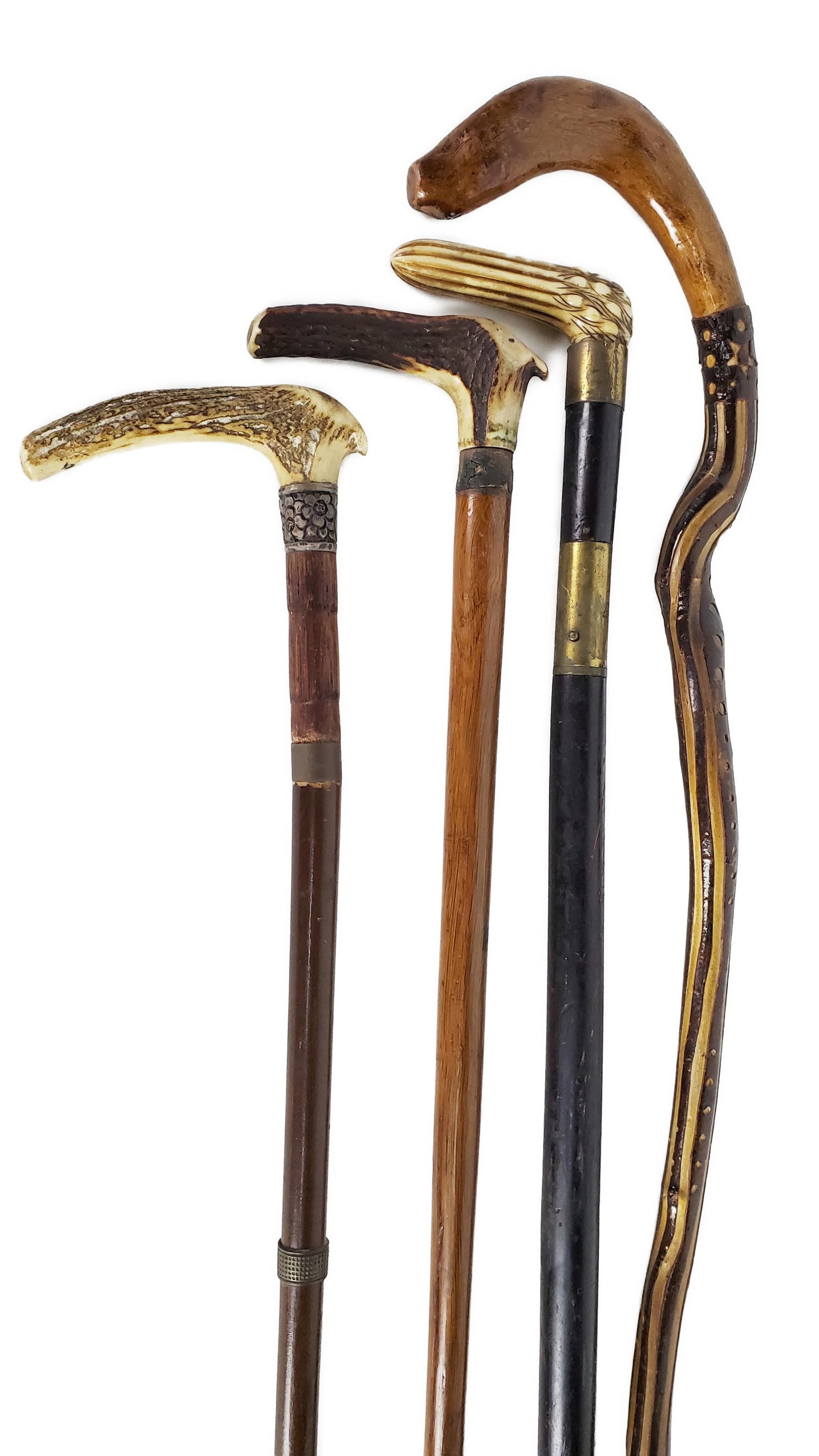 Group of Four Antique Canes to include: two canes with antler horn handles, one sword cane with: Group of Four Antique Canes to include: two canes with antler horn handles, one sword cane with carved bone handle, and one folk wood carved cane,