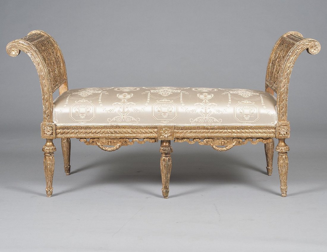 ROCOCO STYLE CARVED AND GILTWOOD WINDOW BENCH: Italian. 19th Century. With rectangular upholstered seat flanked by pierce carved rolled arms, raised on circular tapering reeded legs. Length 50 3/4". (500/700)