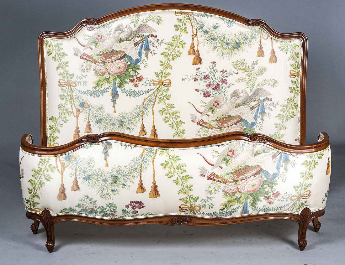 PROVINCIAL STYLE FRUITWOOD BEDSTEAD: The headboard and footboard upholstered in a print fabric. Width 63 ½”. (150/200)