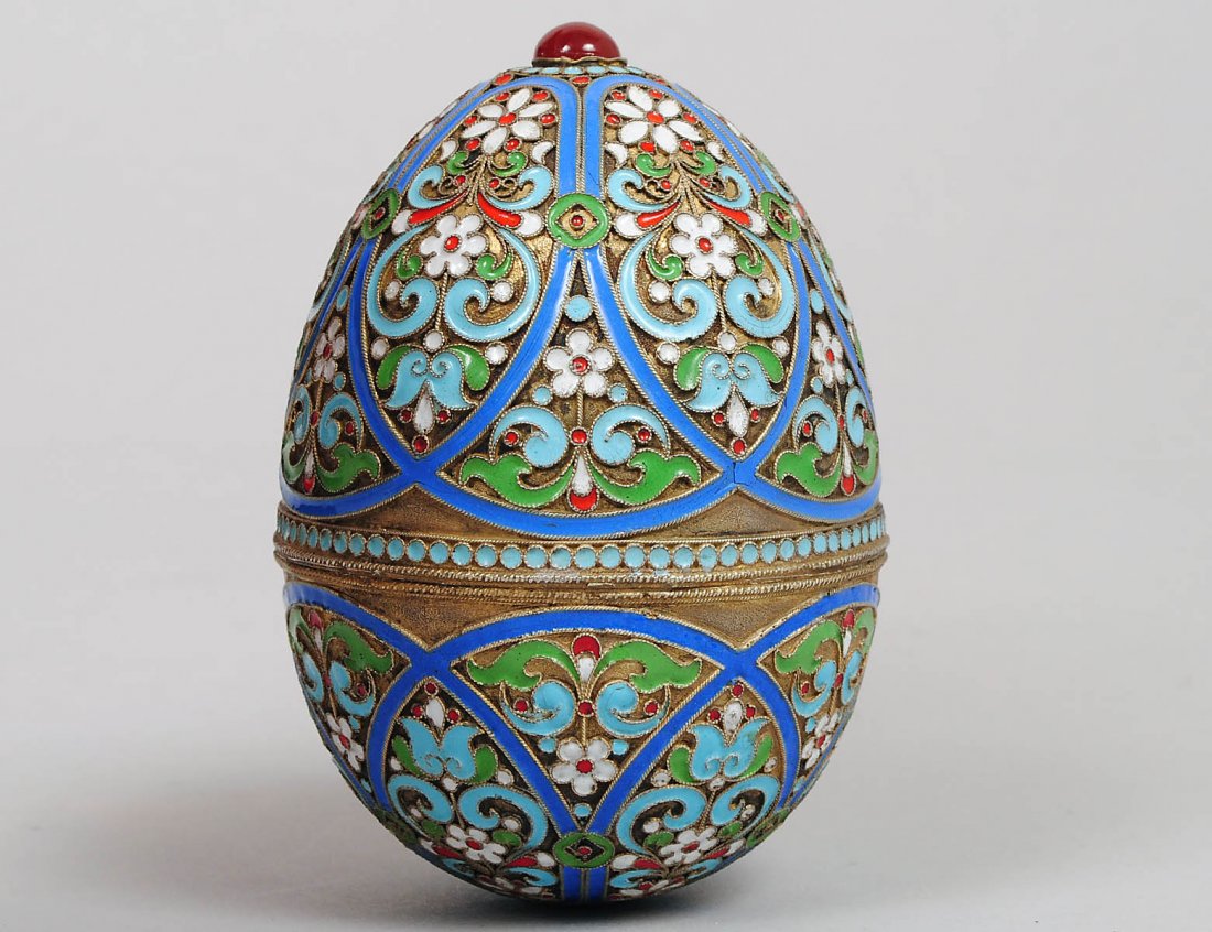 RUSSIAN SILVER GILT AND ENAMEL EGG: Moscow. 1908-1917. (.88 Standard) Decorated with multi-color enamel scrolls and flower heads in the Pan-Slavik style. Height 4”. (Cond: top and bottom now glued) (1200/1600)