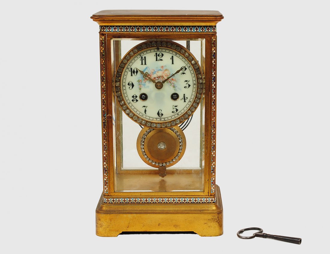 TIFFANY BRASS AND CHAMPLEVE REGULATOR CLOCK: French. Circa 1920. Movement stamped Tiffany & Co. and No. 4548. The circular dial with glass jewels. Height 10 ½”. (400/500)