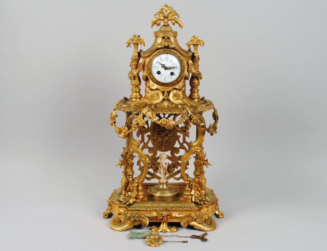 LOUIS XVI STYLE GILT BRONZE MANTEL CLOCK: French. Late 19th Century. Cast as a garden pergola centered by an associated carved ivory figure of a man, surmounted by the clock case under a tent. Height 25 ¼”. (2000/3000)