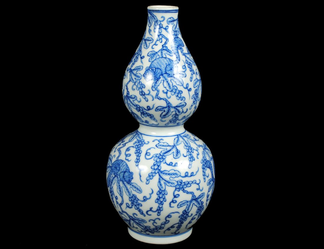BLUE AND WHITE PORCELAIN VASE: Chinese. 19th Century. Of double gourd form, decorated with squirrels on branches. Height 7 1/4". (400/500)