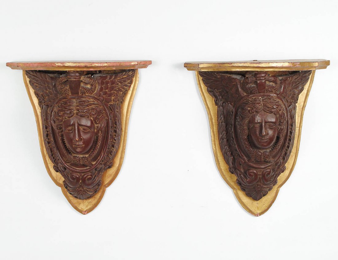 PAIR OF NEO-CLASSICAL STYLE CARVED WOOD BRACKETS: Italian. 20th Century. Each female mask surmounted by wings and enclosed by scrolls, mounted on a giltwood backplate. Height 18 7/8". (500/700)