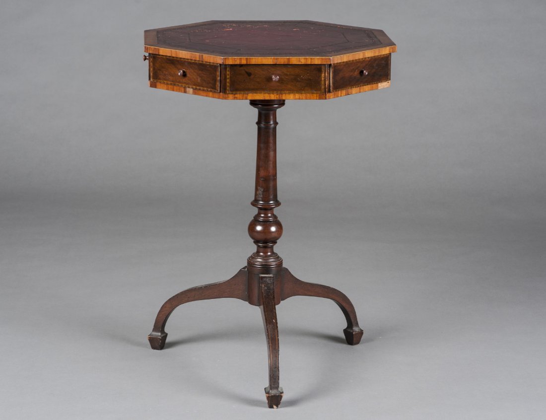 GEORGE III STYLE MAHOGANY DRUM TABLE: English. Early 20th Century. The octagonal top with tooled leather inset above four short and four false drawers, raised on a vase form standard supported by downswept legs. Height 27 ¾”. Diameter 