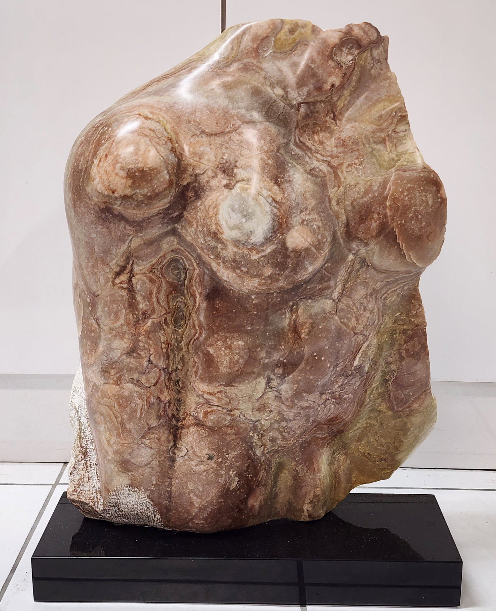 A Contemporary Stone Carved Sculpture of a Male Torso: A Contemporary Stone Carved Sculpture of a Male Torso on a black marble base, 21 1/2" h. Overall-24", this item is heavy.