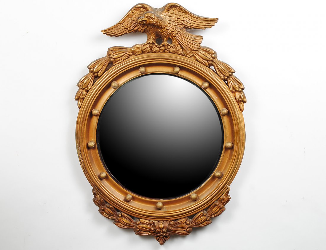 CHIPPENDALE STYLE CARVED AND GILTWOOD CONVEX MIRROR: With eagle finial. Diameter 18 1/2". (100/500)