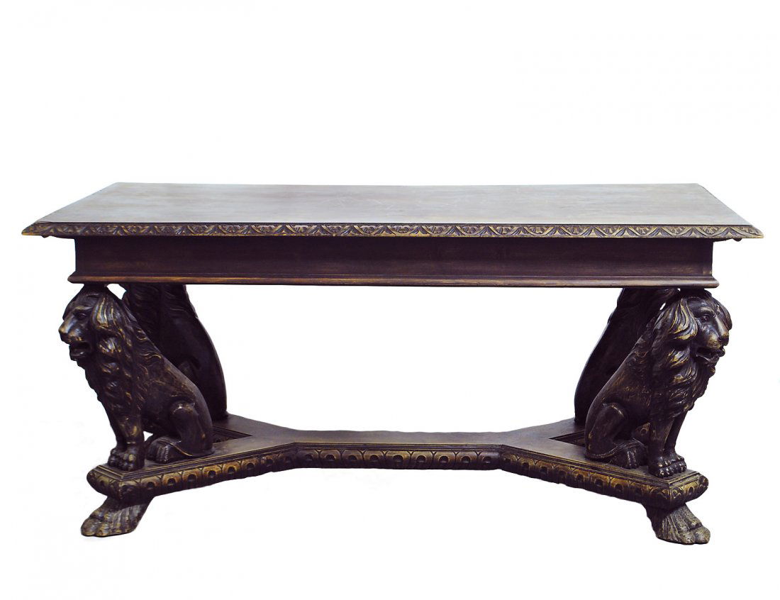 HEAVILY CARVED OAK DINING TABLE: Circa 1900. The rectangular top with lappet edge above four lion terminals seated on a double Y stretcher, raised on paw feet. Height 31 1/4". Width 69 1/2". Depth 38". (100/500)