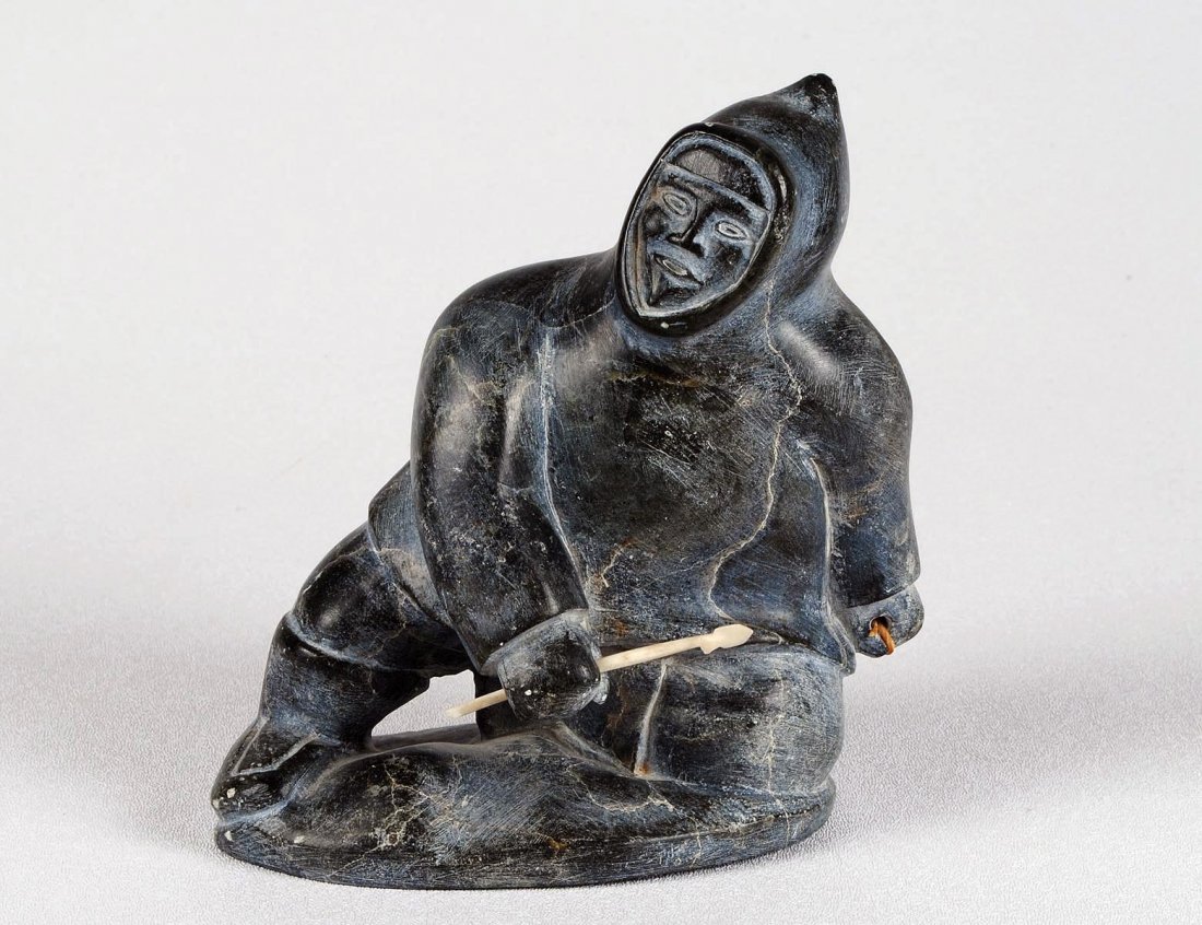 STONE CARVING OF A HUNTER: Inuit. The kneeling figure holding an arrow. Height 6 1/8". With original Canadian government label. (100/500)