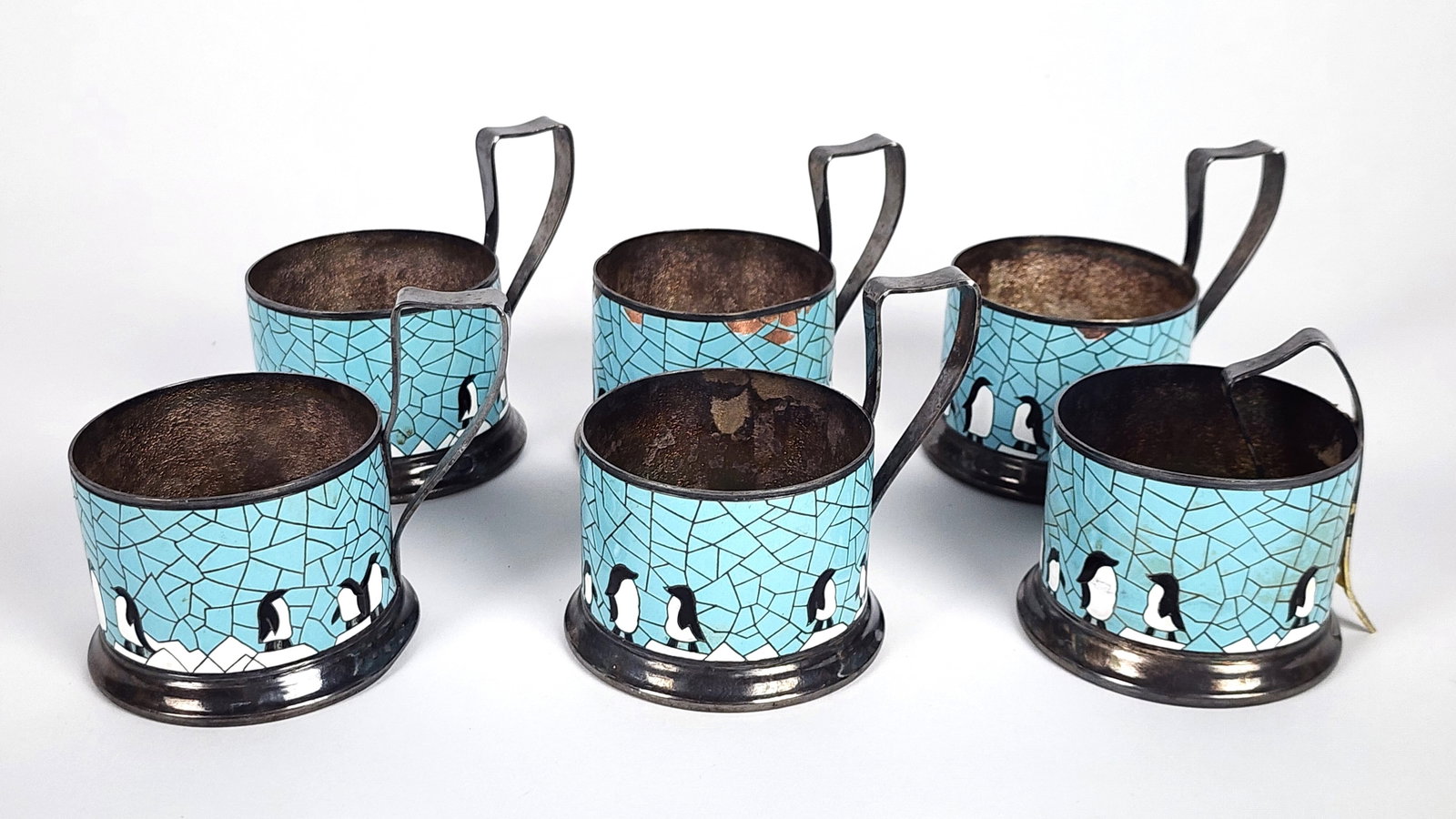 Six Russian Early 20th Century Enamel and Metal Podstakannik (Glass Sleeve Holders) with Penguins,: Six Russian Early 20th Century Enamel and Metal Podstakannik (Glass Sleeve Holders) with Penguins, underside with cyrillic mark, 3 1/2" h. 2 1/2" dia., One handle detached and several with chips and l
