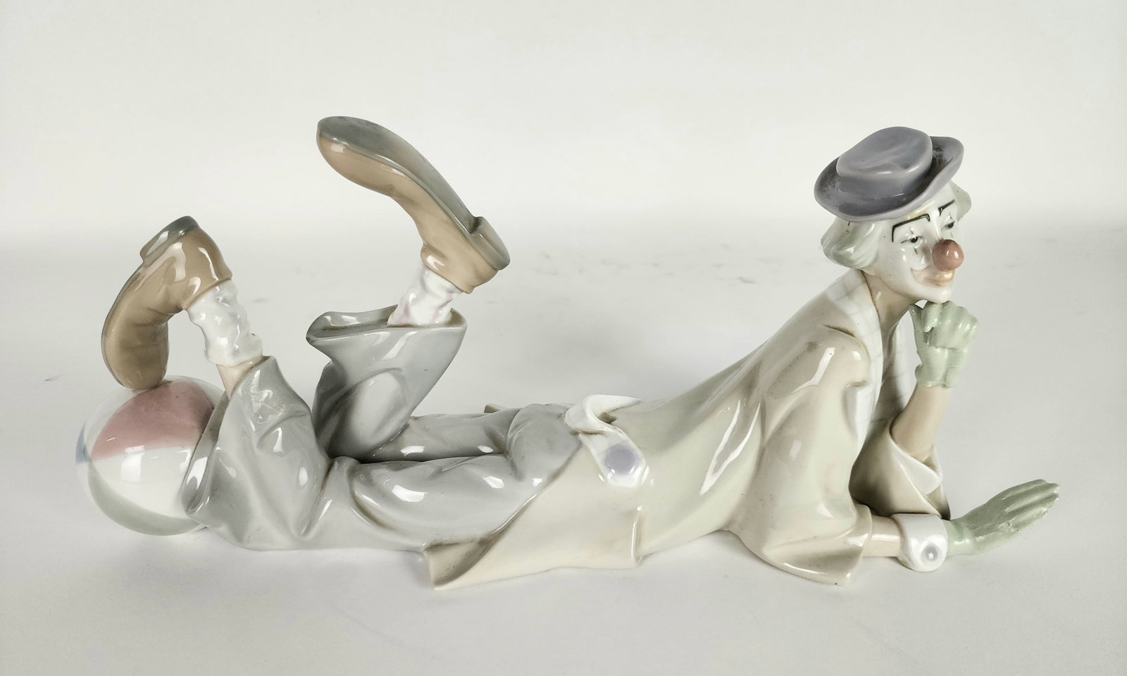 Lladro Porcelain Figure of Clown with Ball, underside marked, 6" h. 14 3/4" L. 5" d., has repairs.: Lladro Porcelain Figure of Clown with Ball, underside marked, 6" h. 14 3/4" L. 5" d., has repairs.