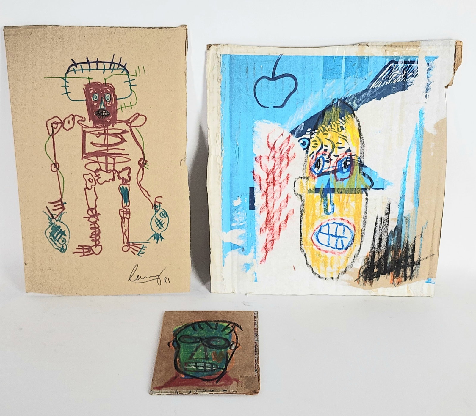 Jean Michel Basquiat (American, 1960-1988) After, Group of Three Drawings on Cardboard, one bearing: Jean Michel Basquiat (American, 1960-1988) After, Group of Three Drawings on Cardboard, one bearing a stamp of certification from Gerard Basquiat, 11 3/4" x11", 12 3/8" x 7 1/2", 6" x 4 1/4", loose an