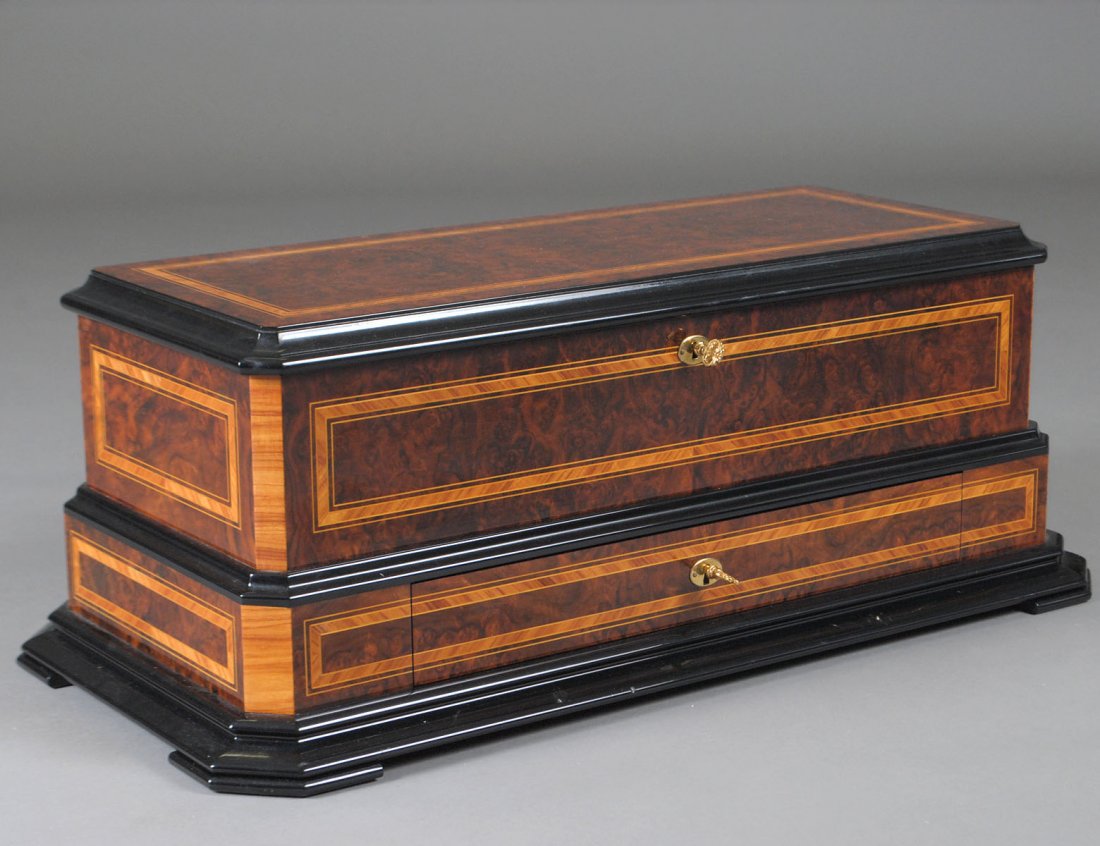 REUGE CYLINDER MUSIC BOX: Swiss. No. 019. With five cylinders 10 1/2" long crank wound, stop/play and change/repeat levers, original music sheet on cover, set in a satinwood cross banded burl case. Length 28 1/2". (1000/1500)