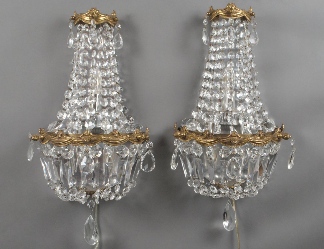 PAIR OF GILT METAL AND GLASS SCONCES: Each shaped backplate supporting a canopy hung with glass beads and pendants. Height 16 1/2". (300/400)