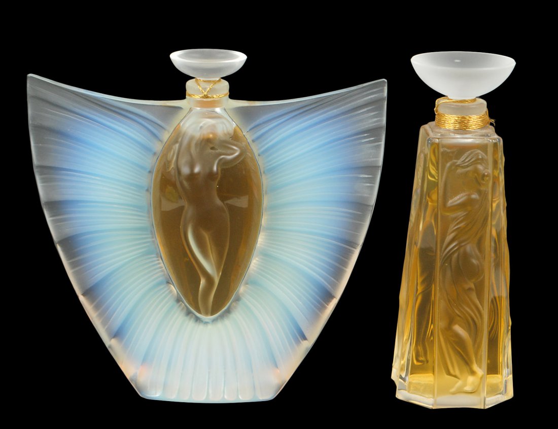 TWO LALIQUE CRYSTAL PARFUME BOTTLES: From the Flacon Collection. The first, "Sulphide". Signed and inscribed AN 2000. Height 5". The second molded with a standing nude on each side. Height 5". Both sealed, never opened. (700/900)