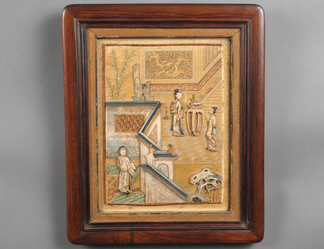 UNUSUAL CARVED AND OVERLAID IVORY AND SOAPSTONE PANEL: Chinese. Qing Dynasty. The painted paper panel depicting a courtyard scene with figures, a pedestal, pine tree and a castle wall. Measuring 9 1/2" by 7 1/4". Set in a wood frame. (Cond: loss to border