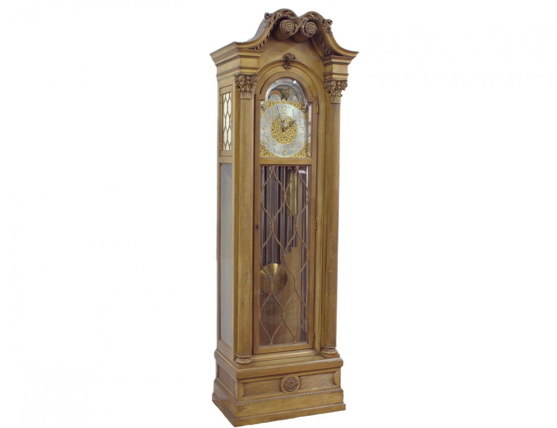 HERSCHEDE TALL CASE CLOCK: American. 20th Century. Serial No. 5542. With moon phase and calendar above the dial and nine tubes contained in the fruitwood case with glazed door and sides. Height 94". (1000/1500)
