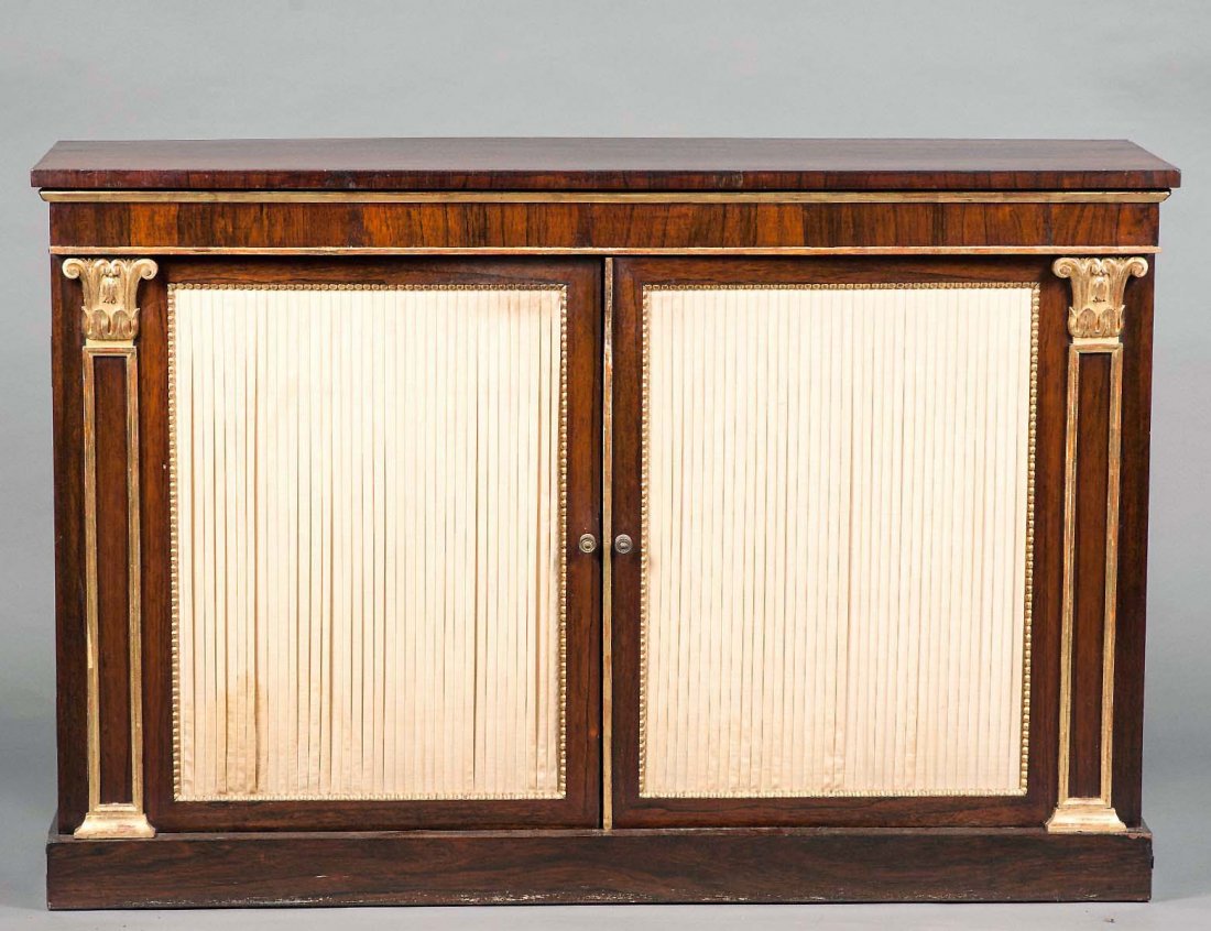 REGENCY PARCEL GILT ROSEWOOD CREDENZA: English. 19th Century. The rectangular top above two doors flanked by half columns, raised on a conforming plinth. Height 35 3/4". Width 54". Depth 16". (800/1200)