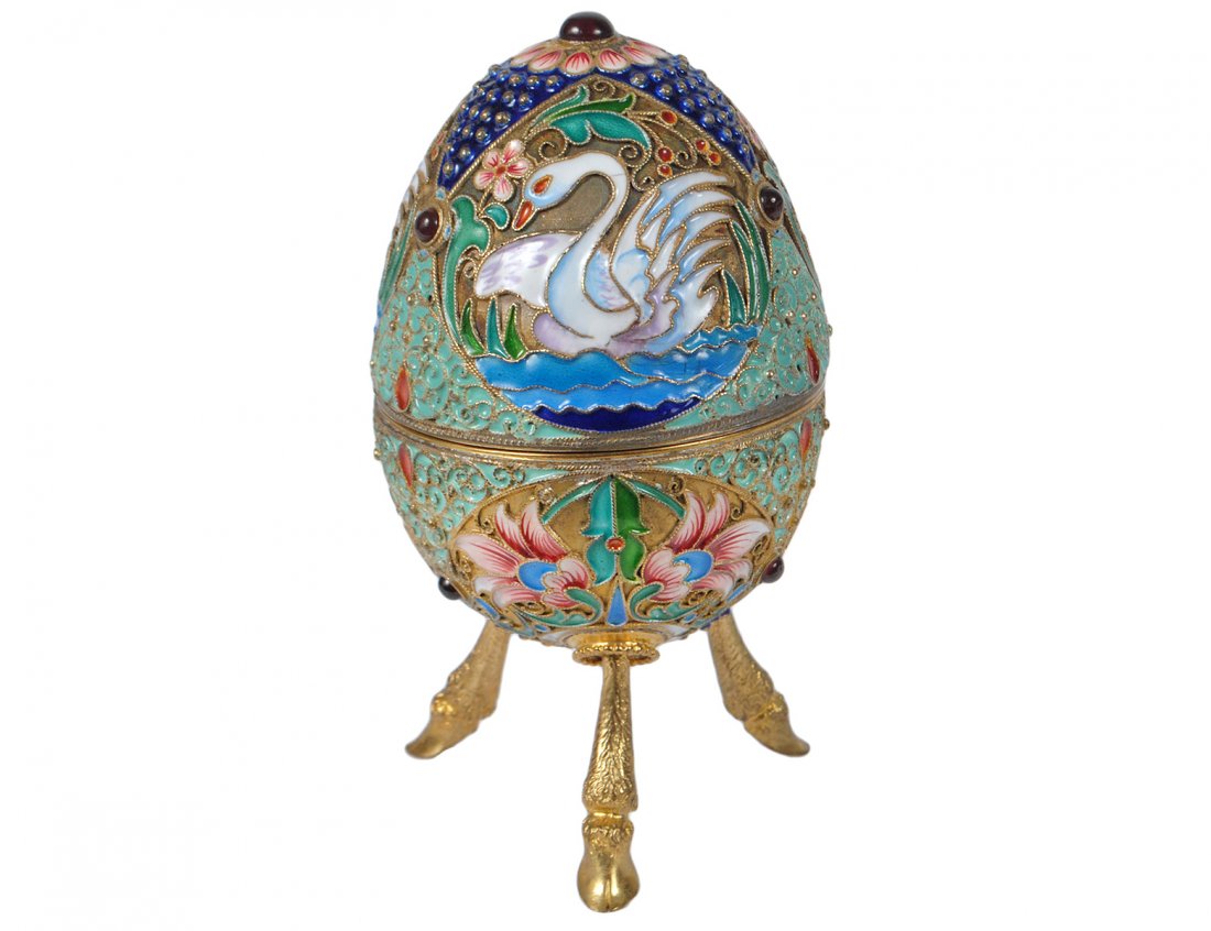 PARCEL GILT STERLING SILVER AND SHADED ENAMEL EGG: Russian. Stamped Sterling. Raised on ram's form legs, decorated with swans and foliage. Height 3 3/4". (600/800)