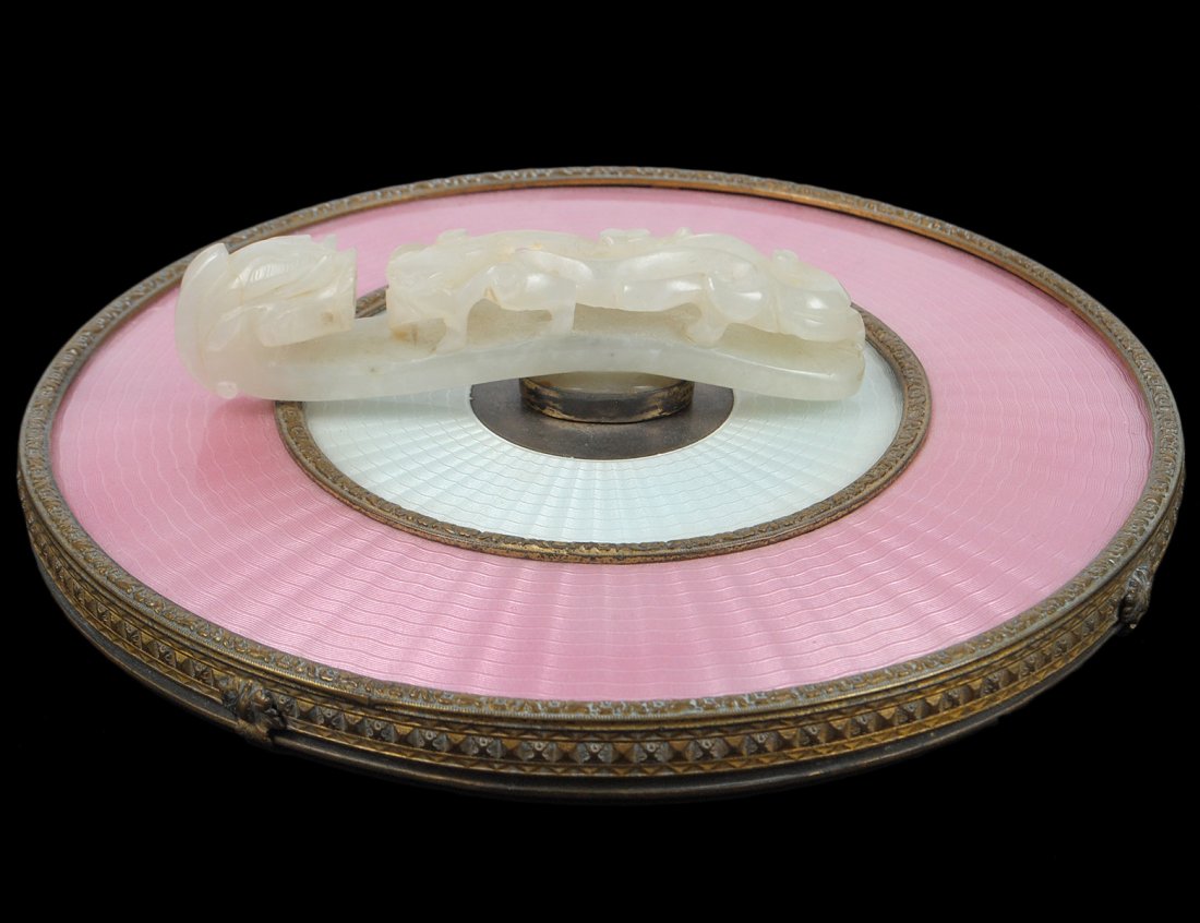 GUILLOCHE ENAMEL HAND MIRROR: European. Of circular shape, mounted with a carved jade belt buckle. Diameter 6 1/2". (300/400)