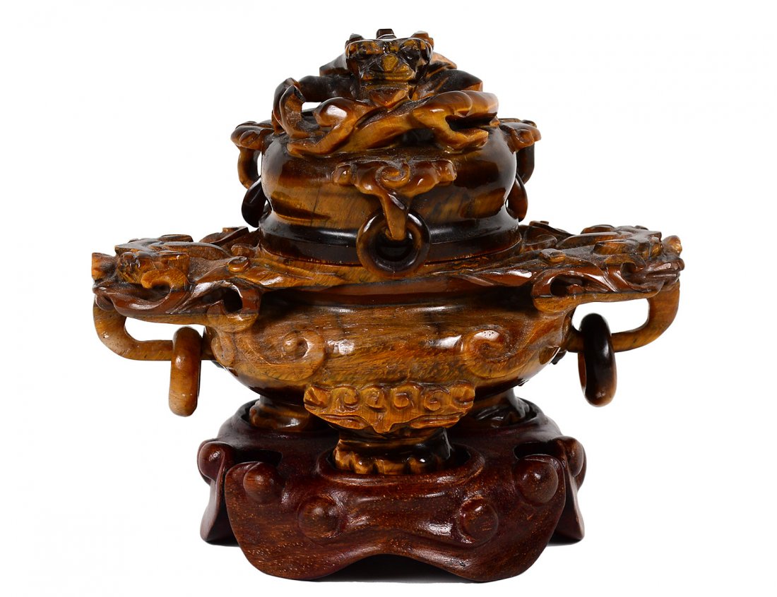 TIGER EYE KORO AND COVER: Chinese. With loose ring and archaic mask handles, the cover with dragon finial. Height 3 1/4". On a wood base. (200/300)