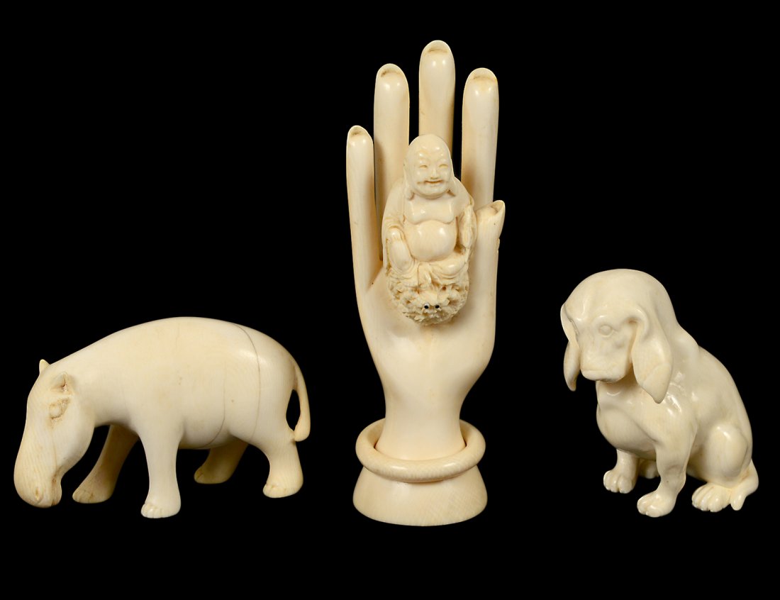 GROUP OF THREE IVORY STUDIES: Comprising: seated dog, height 3"; horse, length 3 7/8"; and a hand with a seated Buddha, height 6". (250/350)Domestic and International shipping is not available for this item. This item can only be