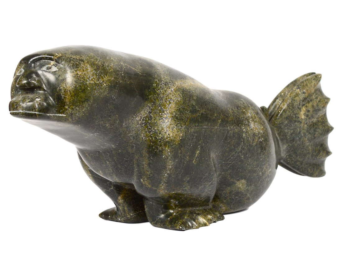 INUIT CARVED SOAPSTONE "SEAL MAN": Case Dorset. By Kelly Etidloie. Signed. Length 21 1/2". (700/900)