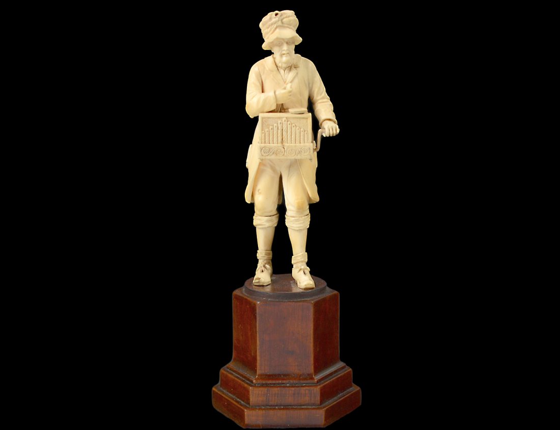 FINE CONTINENTAL IVORY FIGURE OF AN ORGAN GRINDER: Probably French. 19th Century. Height 6 7/8". Mounted on a wood pedestal. (100/500)
