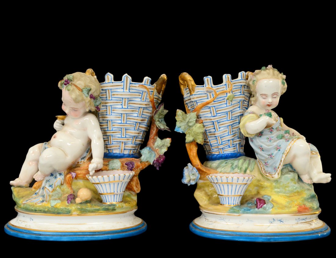 PAIR OF CONTINENTAL PORC FIGURAL VASES: European. Circa 1920. Each modeled as a vase flanked by a figure. Height 6 Â½â€. (Cond: one basket restored, minor chips) (150/200)