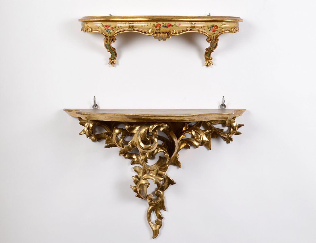 TWO CARVED AND GILTWOOD WALL BRACKETS: Italian. The first with painted top and frieze. Length 20". The second carved with leaves. Length 22 1/2". (100/150)