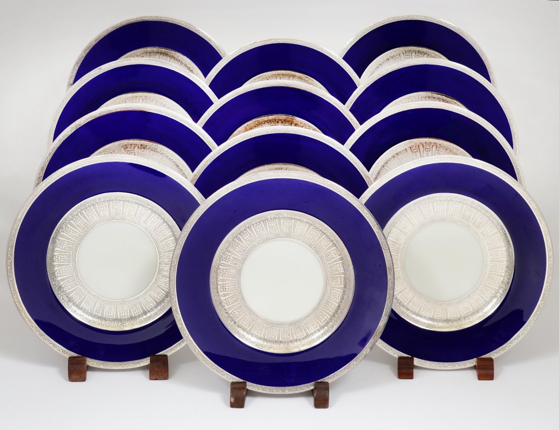 SET OF TWELVE MINTONS PORCELAIN DESSERT PLATES: English. Date mark for 1931. Printed and impressed factory marks. Applied with heavy silver borders. Diameter 7 3/4". (500/700) Retailed by Tiffany & Co., N.Y.