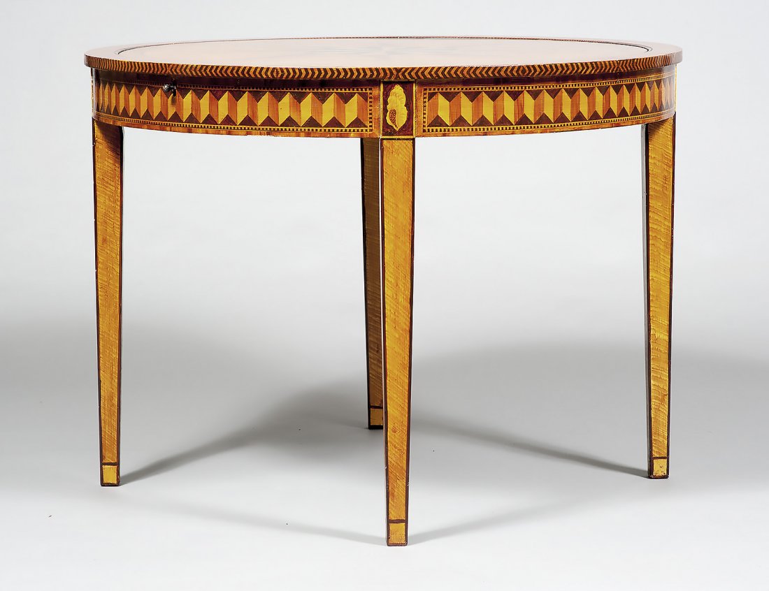 MECHANICAL FAUX INLAY OAK GAME TABLE: The circular top painted faux inlay with ebony and satinwood sunburst design and barber pole borders, with a release mechanism that flips to reveal the gaming board, raised on square tapered legs. Hei