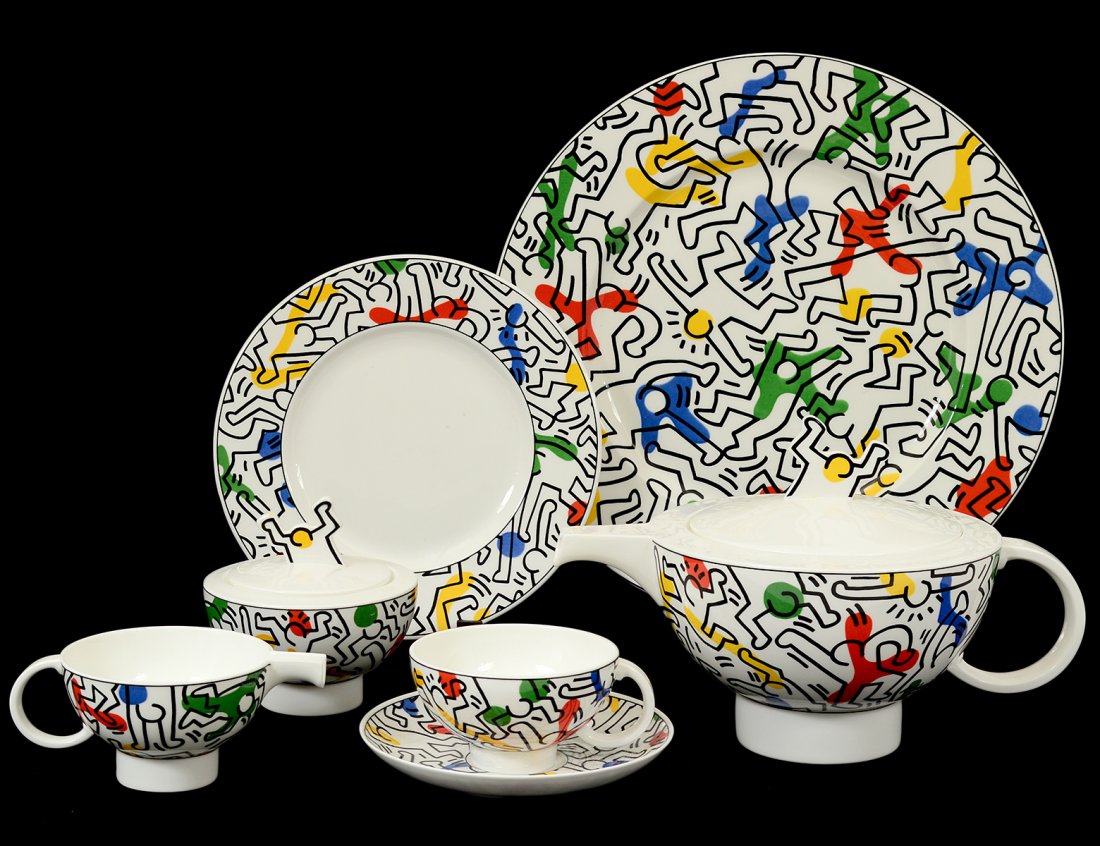 TWENTY-TWO PIECE KEITH HARING PORCELAIN TEA SERVICE: German. 1991. By Villeroy & Boch. Titled "No. 1 Spirit of Art". Comprising: six dessert plates, six cups and saucers, tray, tea pot, covered sugar bowl and creamer. (800/1200)