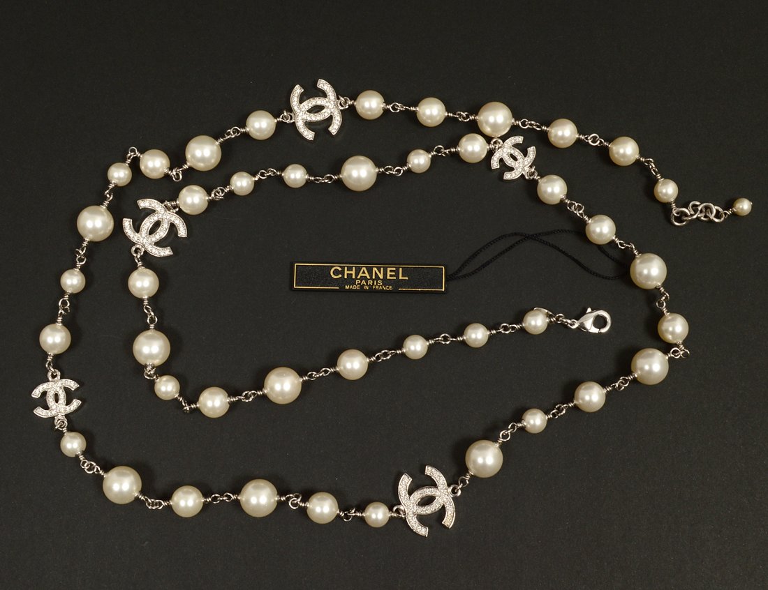 CHANEL FAUX PEARL AND CRYSTAL SAUTOIR NECKLACE: Comprising: five crystal studded interlocking "C" crystals. Length 42". Comes with tag with serial numbers 12A A36121402005 and COL Z2354. (Cond: good) (400/600)