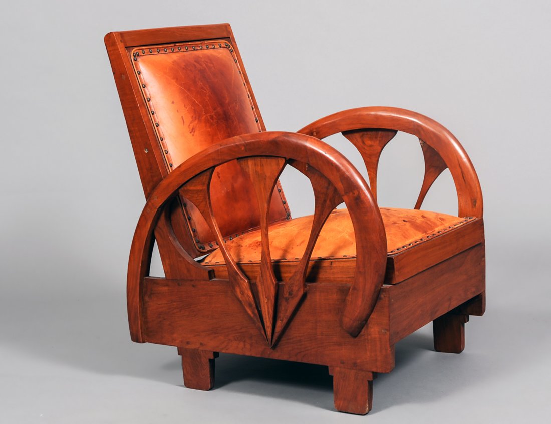 ART DECO MAHOGANY DECK CHAIR: Circa 1925. With rectangular leather upholstered backrest flanked by â€œwheelâ€œ form armrests above the padded removable seat. (400/600)