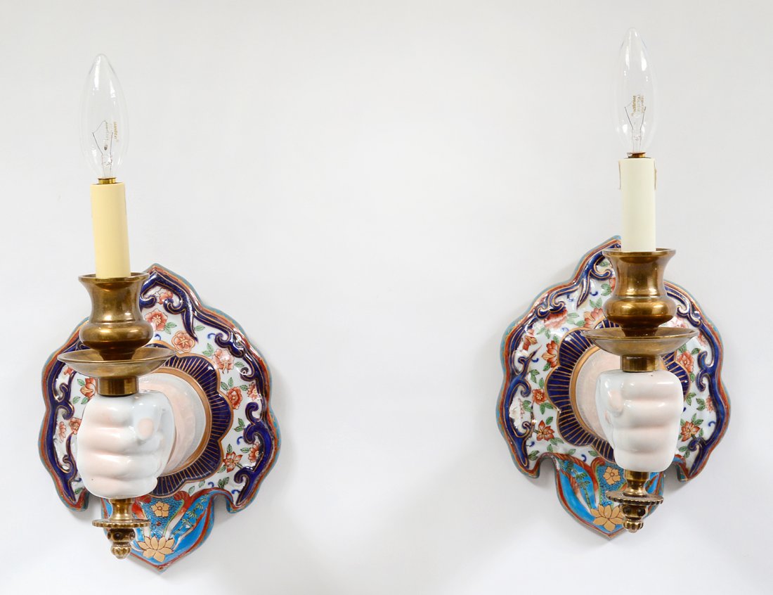 PAIR OF PORCELAIN SCONCES: In the form of a hand holding the brass fitting. Height 11". (100/150)