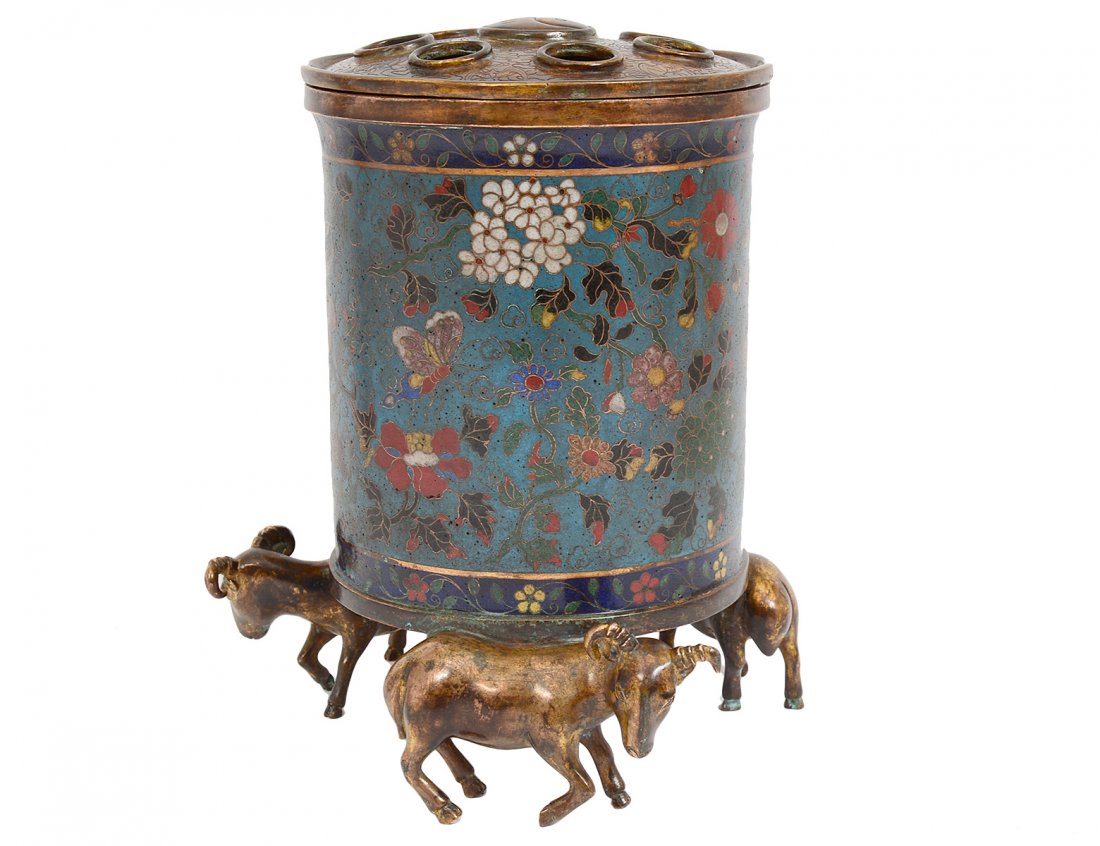 MING DYNASTY STYLE CLOISONNE ENAMEL FLOWER POT: Chinese. With "Jing Tai" mark on the underside. The cylindrical vessel with removable cover supported by ram-form feet for the Year of the Ram. Height 8 1/4". (8000/10000)