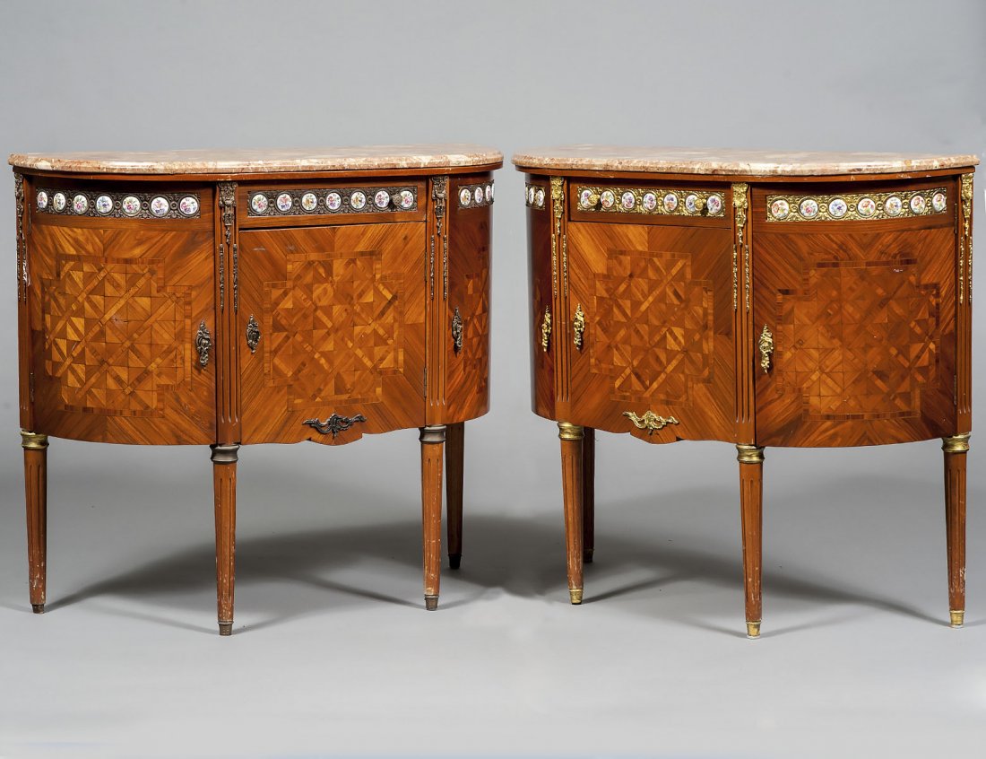 PAIR OF LOUIS XVI STYLE MARBLE TOP COMMODES: Each D-shaped top above a frieze drawer and three cupboard doors, applied with circular porcelain plaques, raised on circular tapered reeded legs. Height 32 1/4". Width 36 1/4". Depth 13 5/8". (1000/1