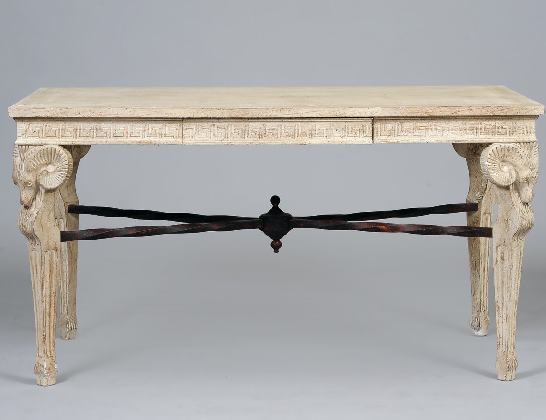 EMPIRE STYLE CARVED AND PAINTED DESK: The rectangular paneled top above a frieze drawer, raised on supports headed by ram's masks and ending in hoofed feet. Height 30 1/8". Width 55 3/4". Depth 27 3/4". (300/400)