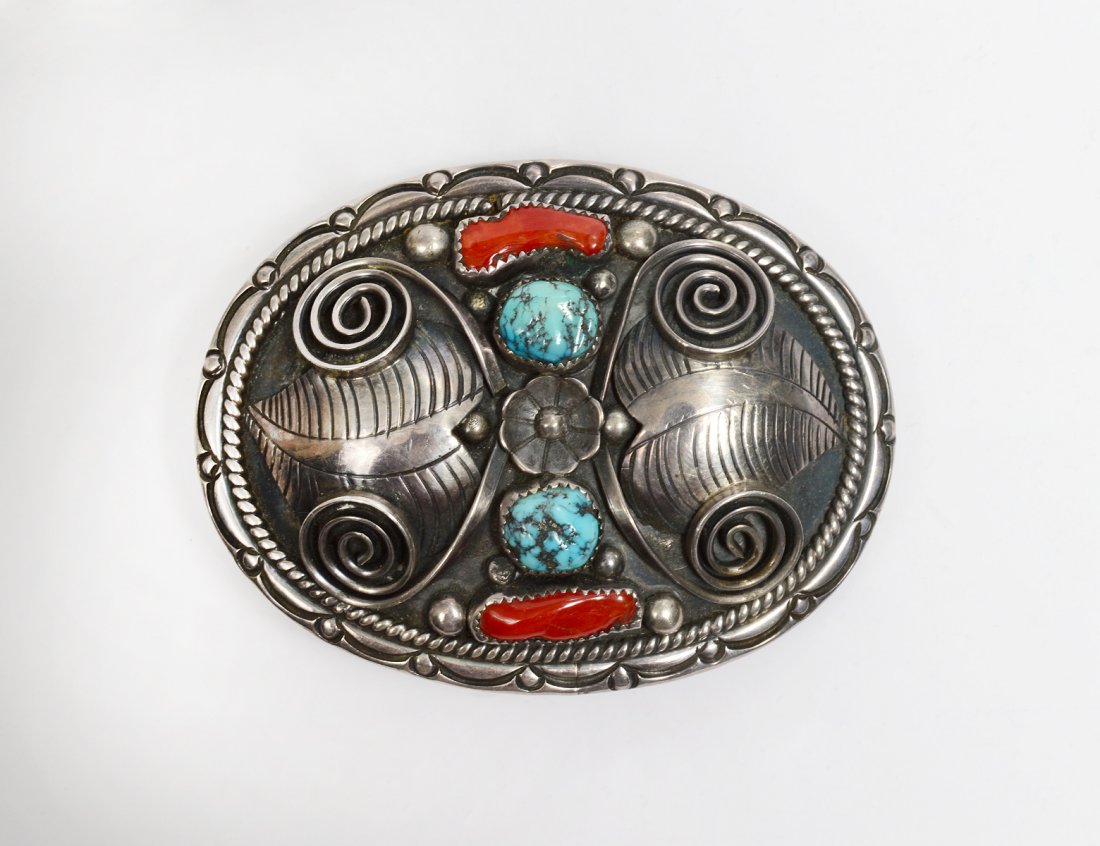 NATIVE AMERICAN STERLING SILVER BELT BUCKLE: Initialed DDC for Dorothy and Donny Clark. Two blue with black matrix cabochons. Two coral cabochons. Appliques of leaves, balls and scrolls. Stampwork. (2.45 oz) (Cond: good) (300/500)