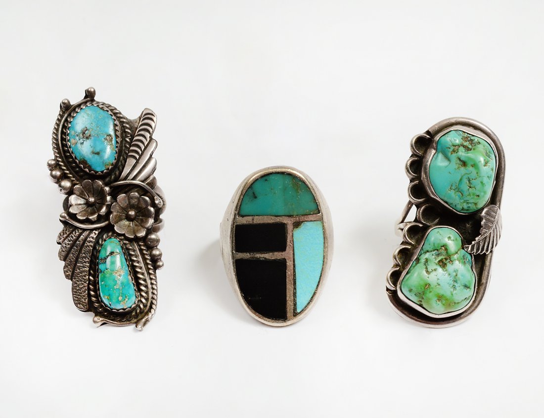 GROUP OF THREE NATIVE AMERICAN STERLING SILVER RINGS: The first signed RB Navajo Handmade probably for Rita Begay or Robert Brown. Two blue turquoise cabochons. Flower, feather, ball and rope applique. Ring size 7. (0.49 oz) The second set with two green